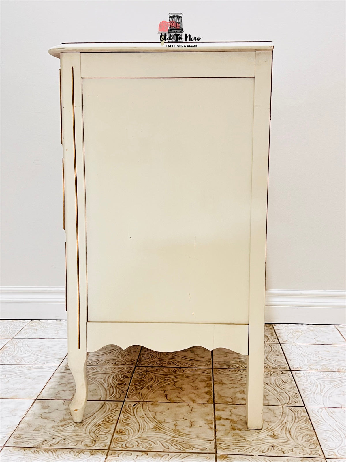 Three drawer wooden dresser on a white floor.