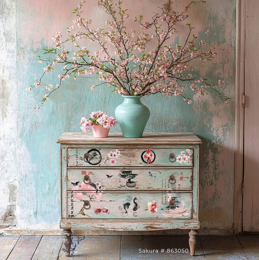 A dresser showing how to use a set of Japanese-themed furniture decals featuring a cherry blossom tree, a bonsai tree, a pagoda, a boat, two koi fish, a goldfish, and a circle with a flower. The decals are in black, white, red, and pink. The text on the decals reads 'FREEDOM', 'TRANQUILITY', 'FIRST ART', 'JAPANESE', 'ZEN', and 'FLOWER'