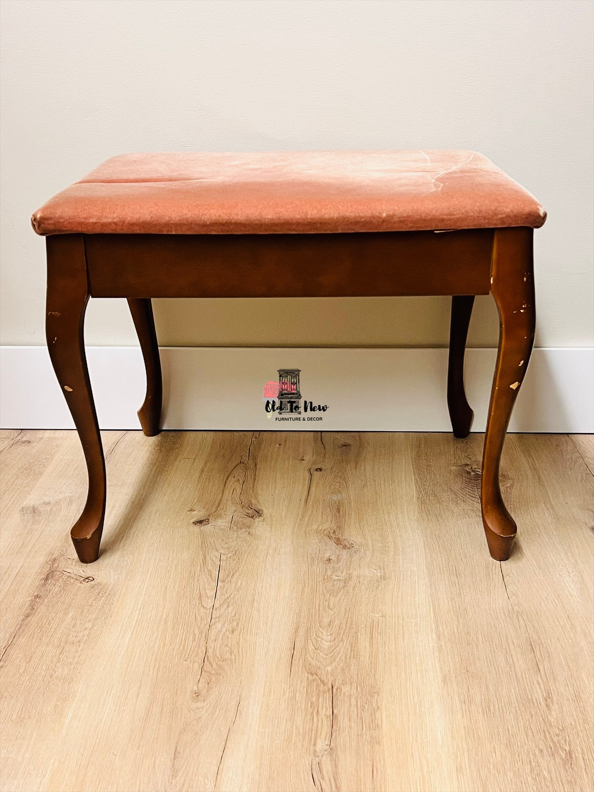Unfinished wooden bench with pink cushion on a wooden floor against a white wall, available for customization 