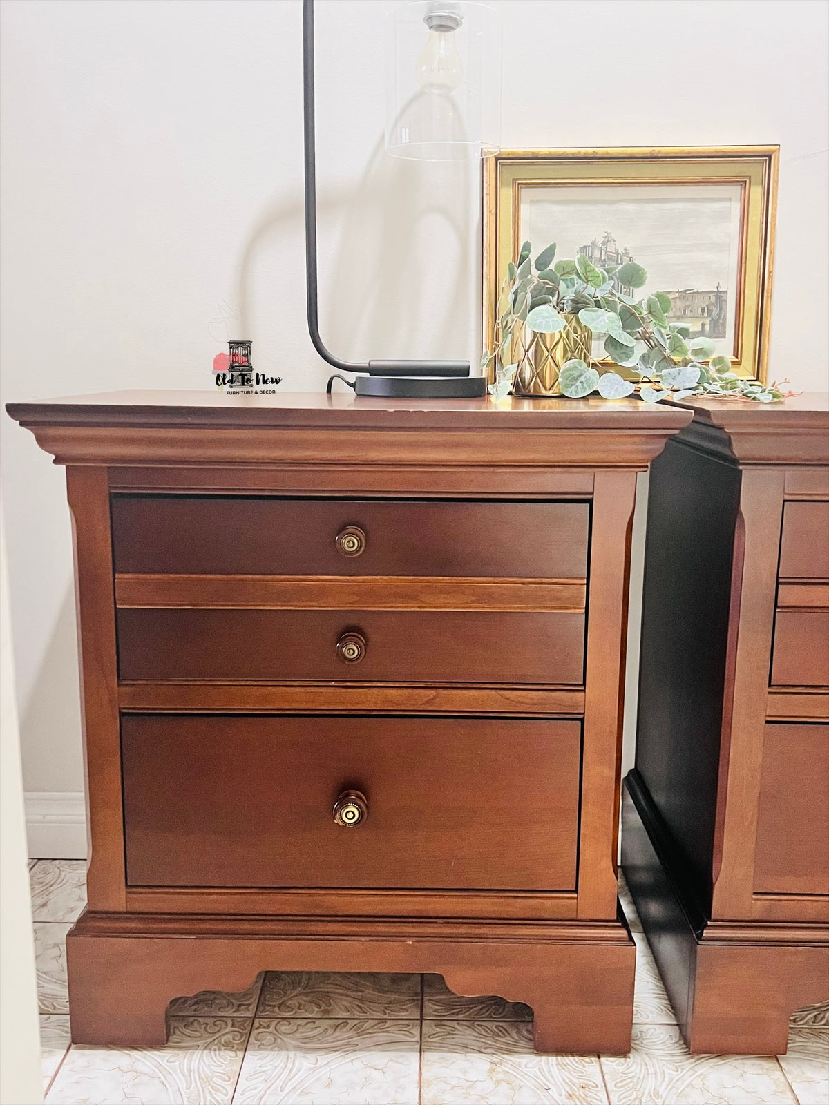 Wooden nightstand with three drawers in a room setting.