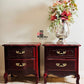 Two wooden French Provincial nightstands with floral arrangement on a tiled floor.