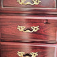 Wooden dresser with gold handles on a dark background