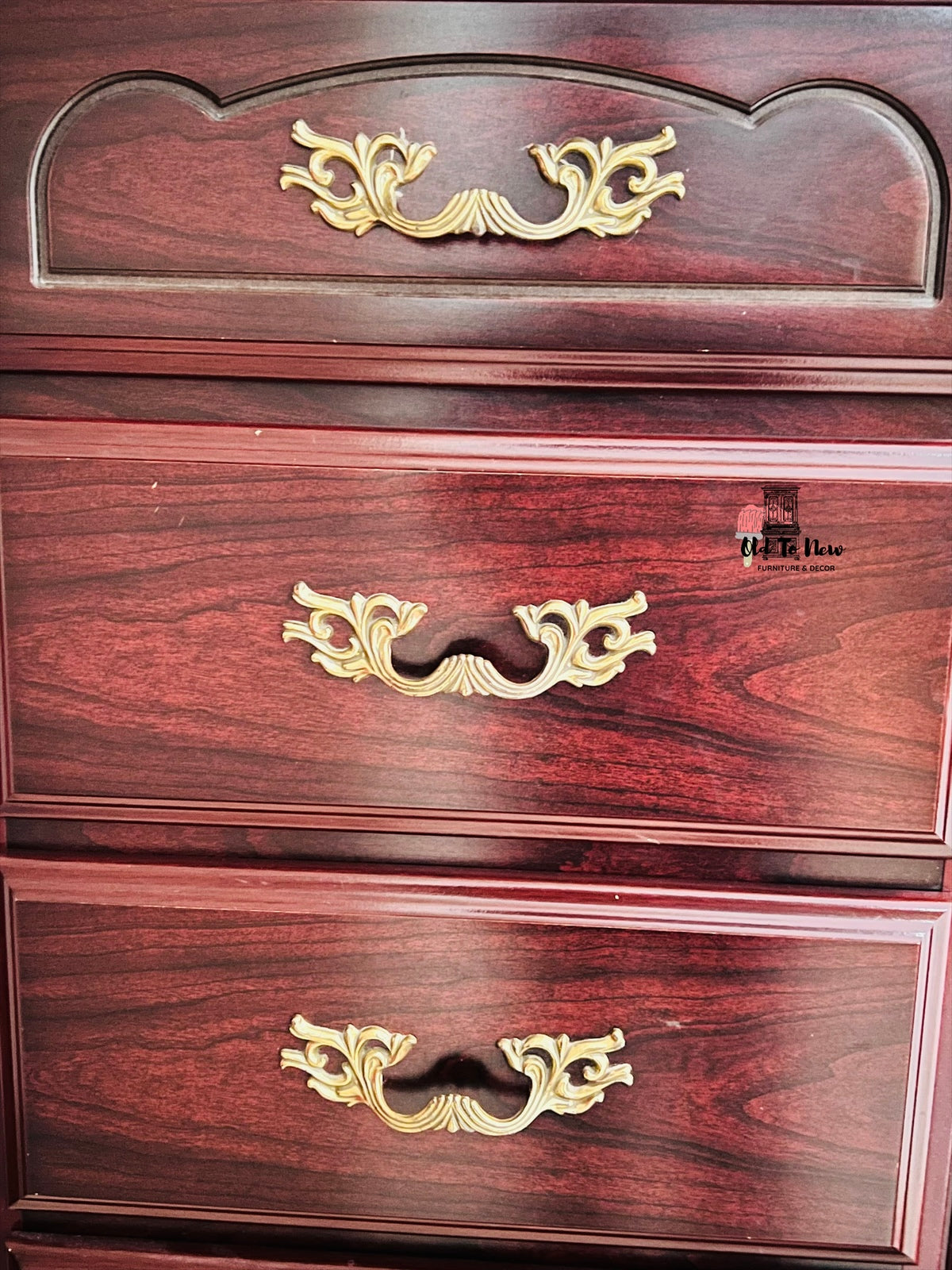 Wooden dresser with gold handles on a dark background