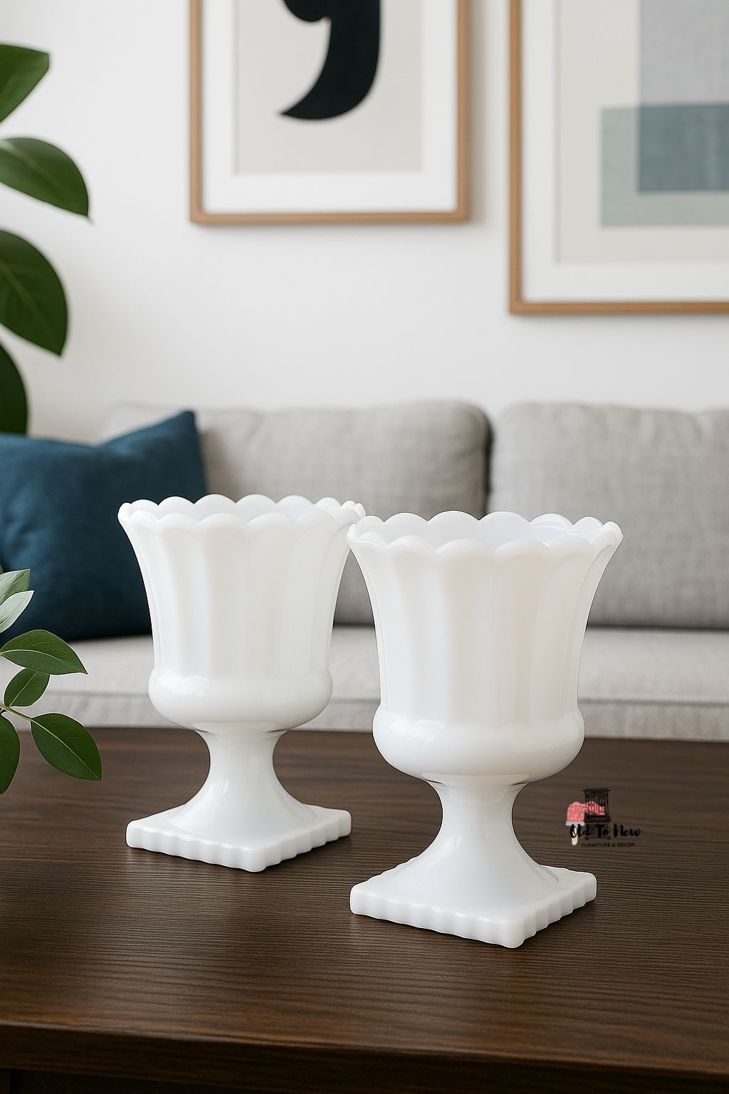  Set of two vintage white milk glass pedestal vases with scalloped rims styled on a light wood surface beside olive branches, ideal for modern or farmhouse home décor.”