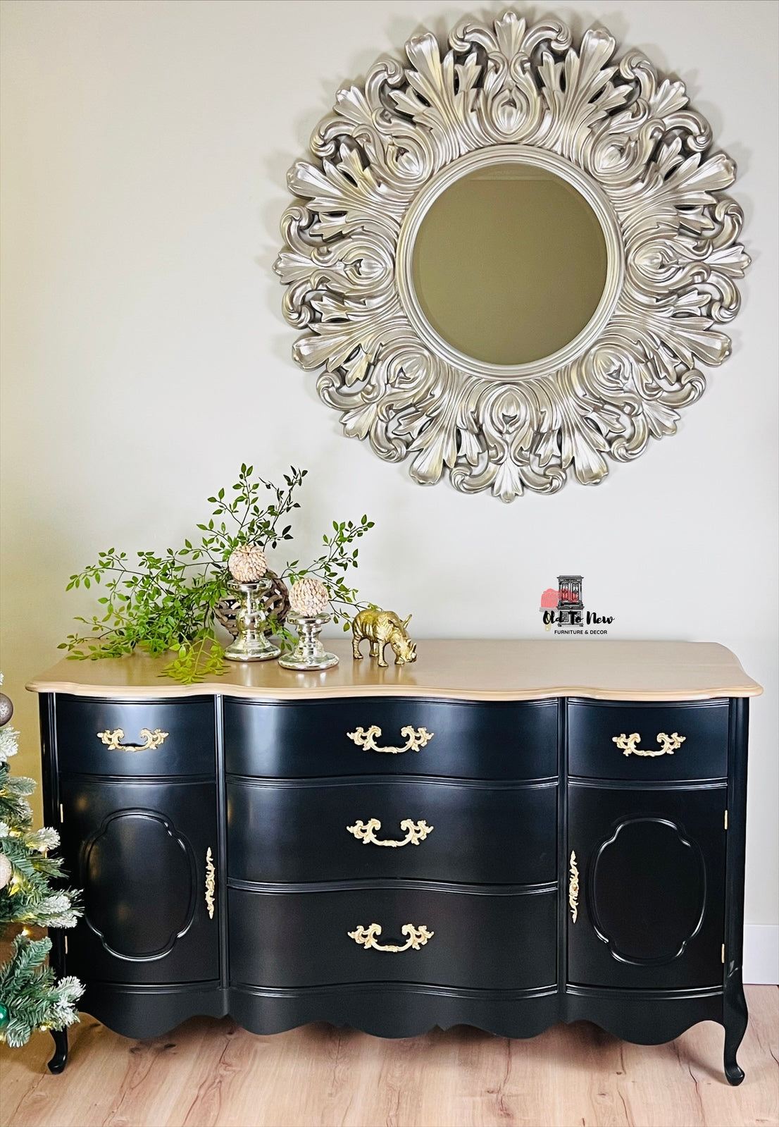 Black dresser with gold accents and decorative mirror in a room setting