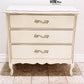 French Provincial three-drawer dresser with decorative handles.