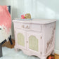 French Provincial Soft blush pink end table with rattan cane inner doors and copper finishes 